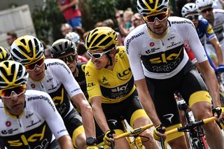 Team Sky surround their overall winner Geraint Thomas through the last stage at the 2018 Tour de France
