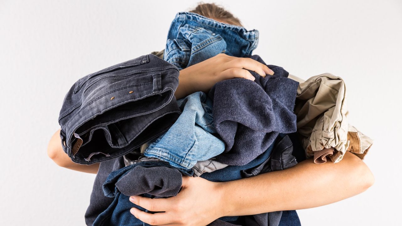 Woman holding lots of jeans