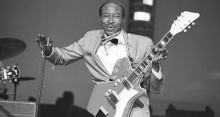 The great Jimmy Reed wears a sharp suit and bow-tie and plays an Airline electric guitar in this archive live shot from 1960