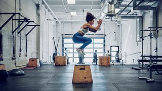 a photo of a woman doing box jumps