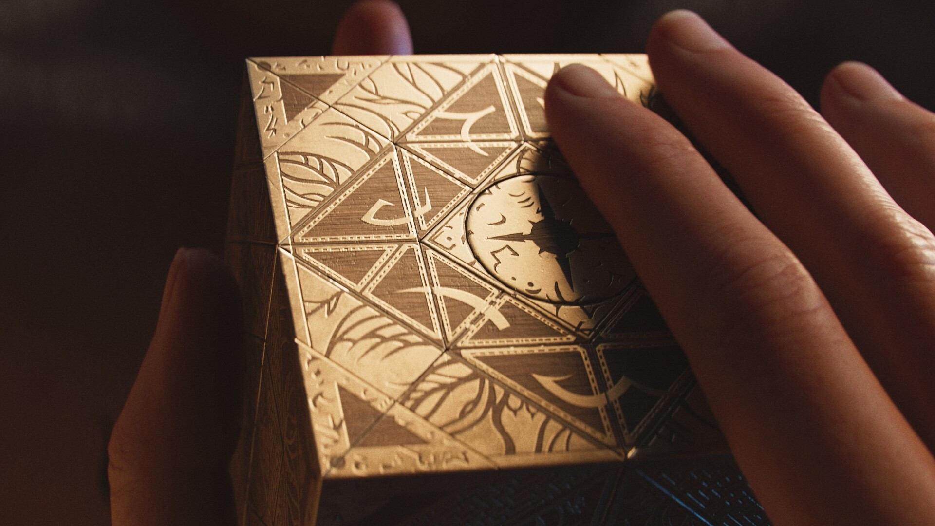 A hand holds and touches the Genesis Configuration in Clive Barker's Hellraiser: Revival