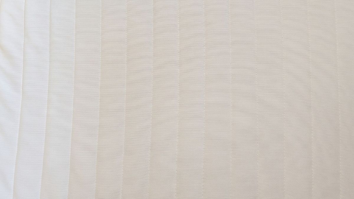 The image shows the bright white surface of the mattress after a thorough deep clean to remove yellow stains