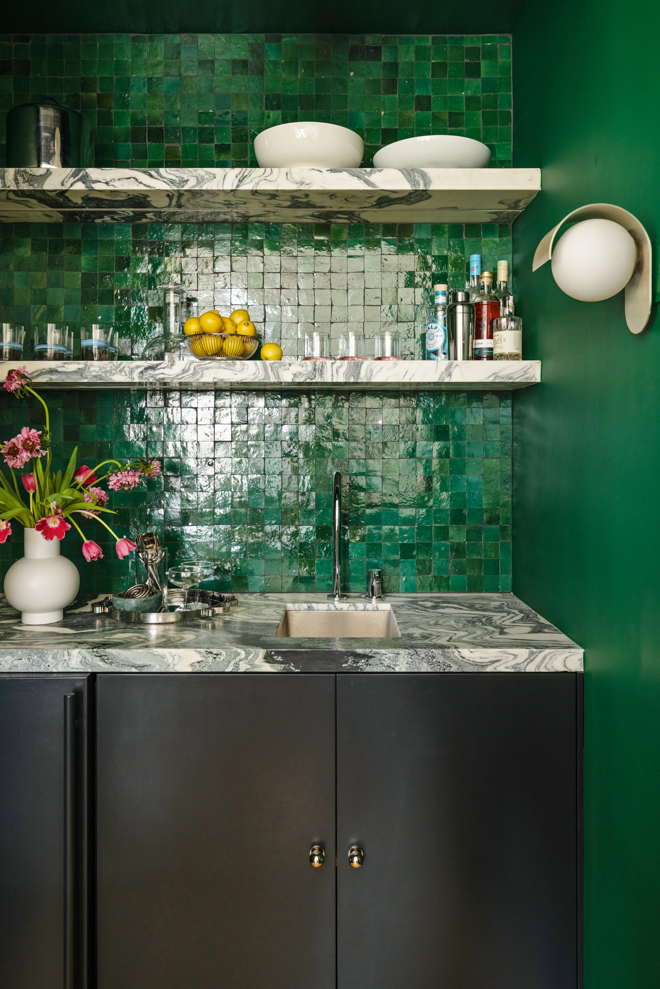Wet bar with dark blue cabinetry, grey and white marble countertop, and emerald green mini zellige tile backsplash