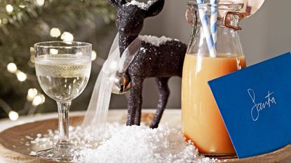 Glass and bottle of orange juice on a tray with a letter to santa