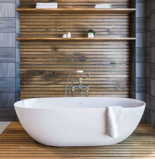 a bath in front of a timber panelled wall