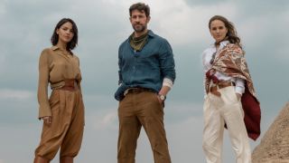 From left to right: Eiza González, John Krasinski and Natalie Portman all standing in The Fountain of Youth in front of the pyramids. 