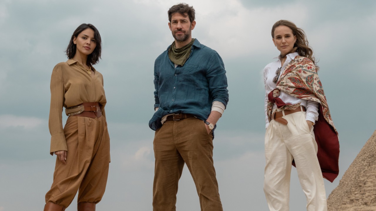 From left to right: Eiza González, John Krasinski and Natalie Portman all standing in The Fountain of Youth in front of the pyramids.