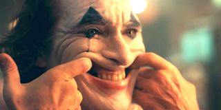 Joaquin Phoenix Joker movie stretching mouth into smile