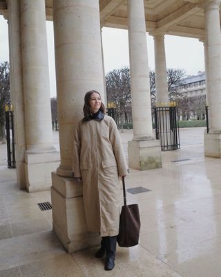 Rue Rodier wears a stone trench coat