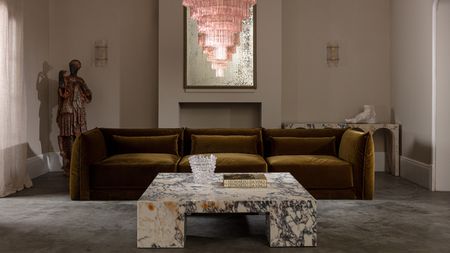 marble coffee table in a large living room beneath a pink chandelier