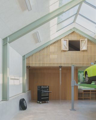 Car raised up inside gallery-like workshop, Autobarn by Bindloss Dawes