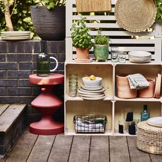 outdoor kitchen storage ideas with crates, tableware, glassware, planters, baskets, jugs