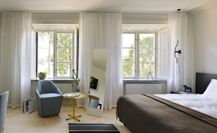Bedroom in white with a brown throw on the bed