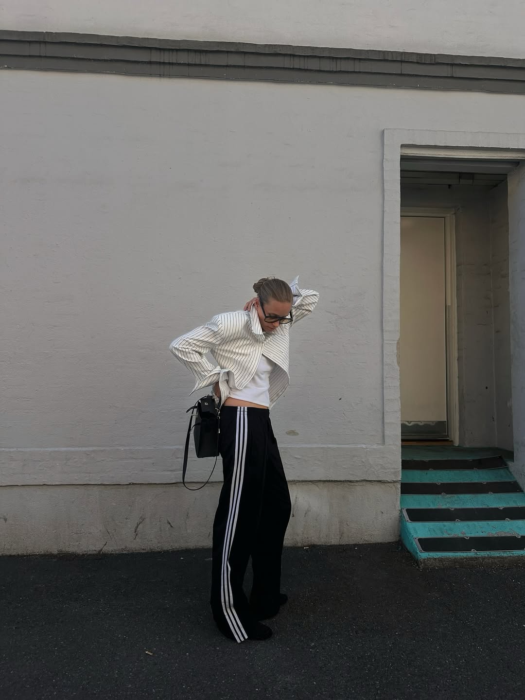 @tineandreaa wears black Adidas tracksuit bottoms and striped white shirt