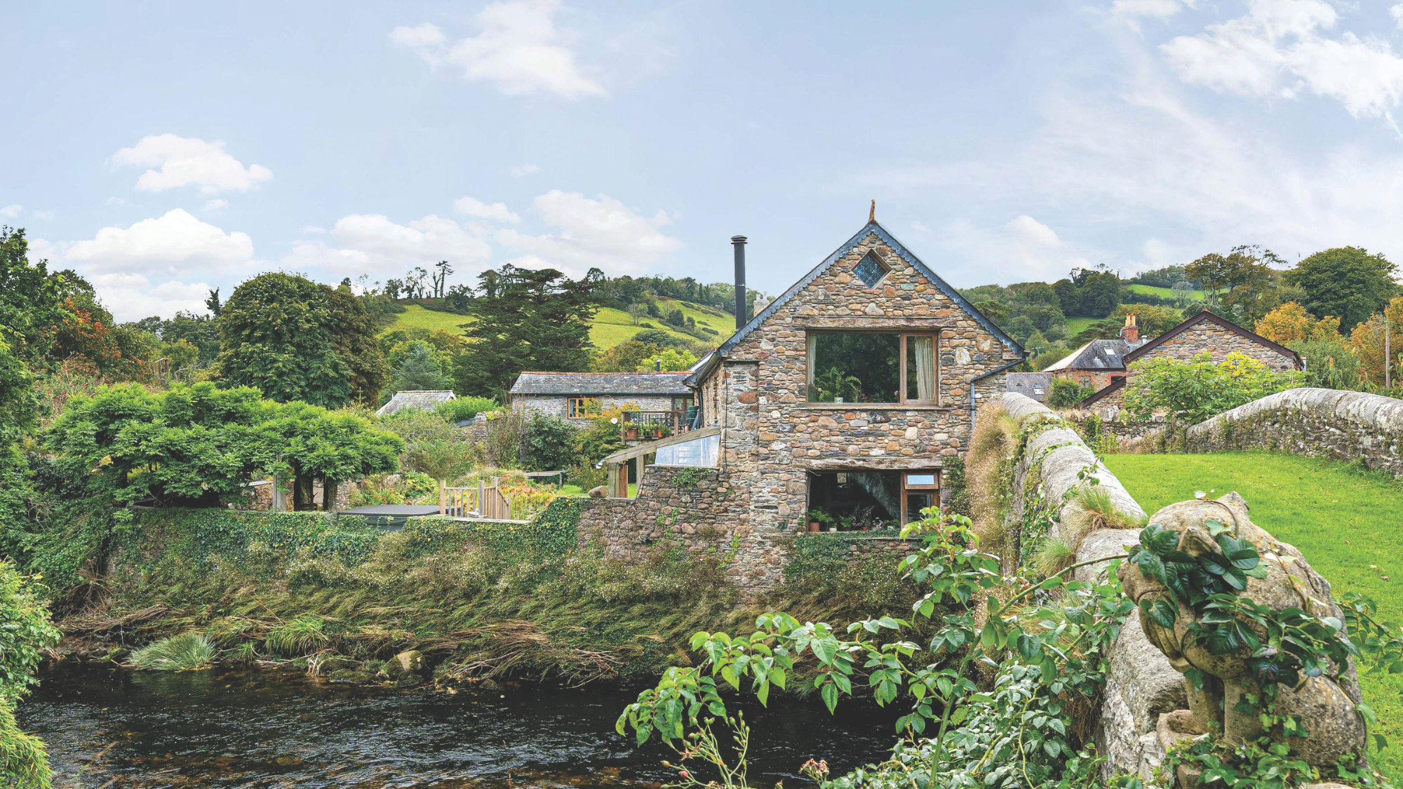 A riverside property surrounded by carefully maintained gardens including a walled orchard.