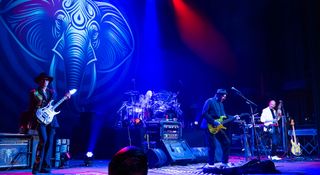 The Beat Tour live onstage, bathed in blue light, Adrian Belew takes centre stage.