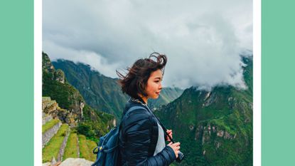 Young Woman Looking At View From Machu Picchu In Peru