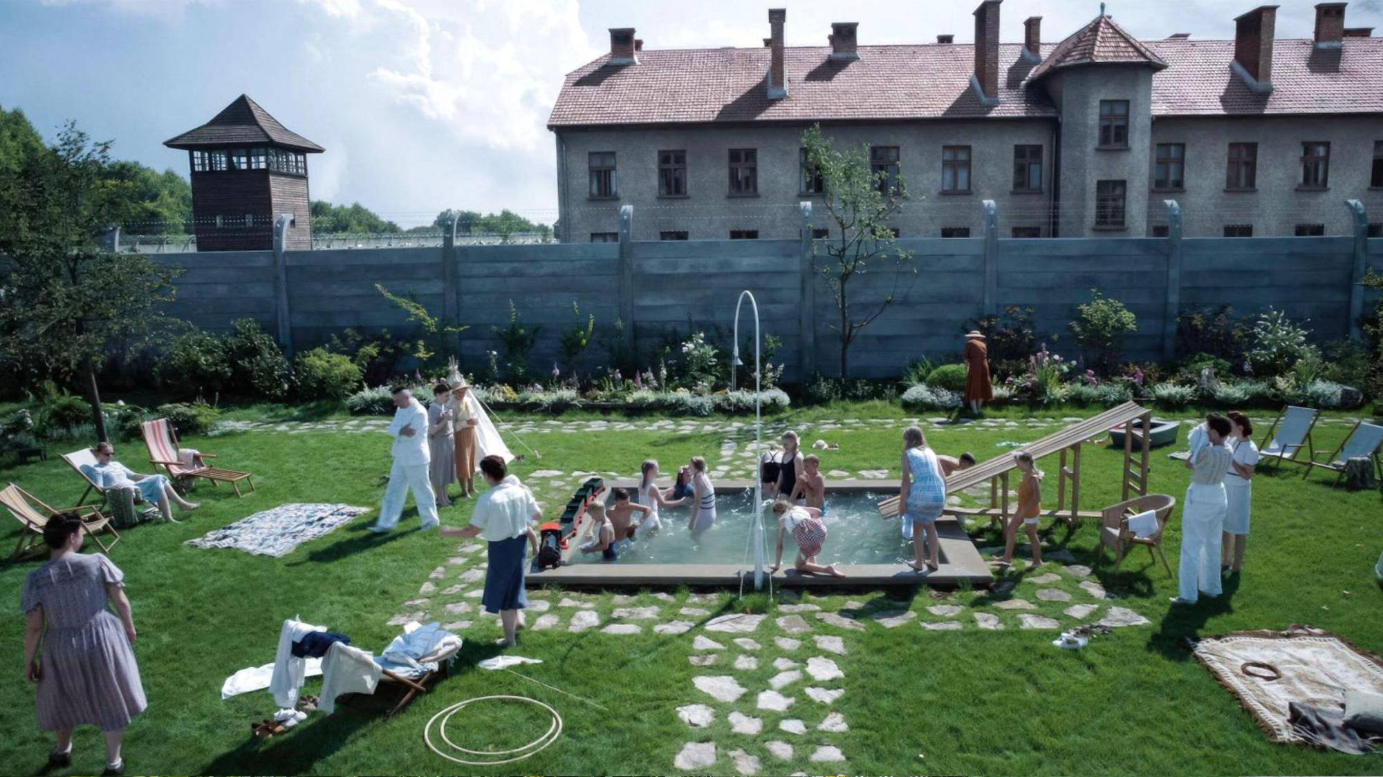 A scene from "The Zone of Interest" showing the Hoss' garden with Auschwitz in the background