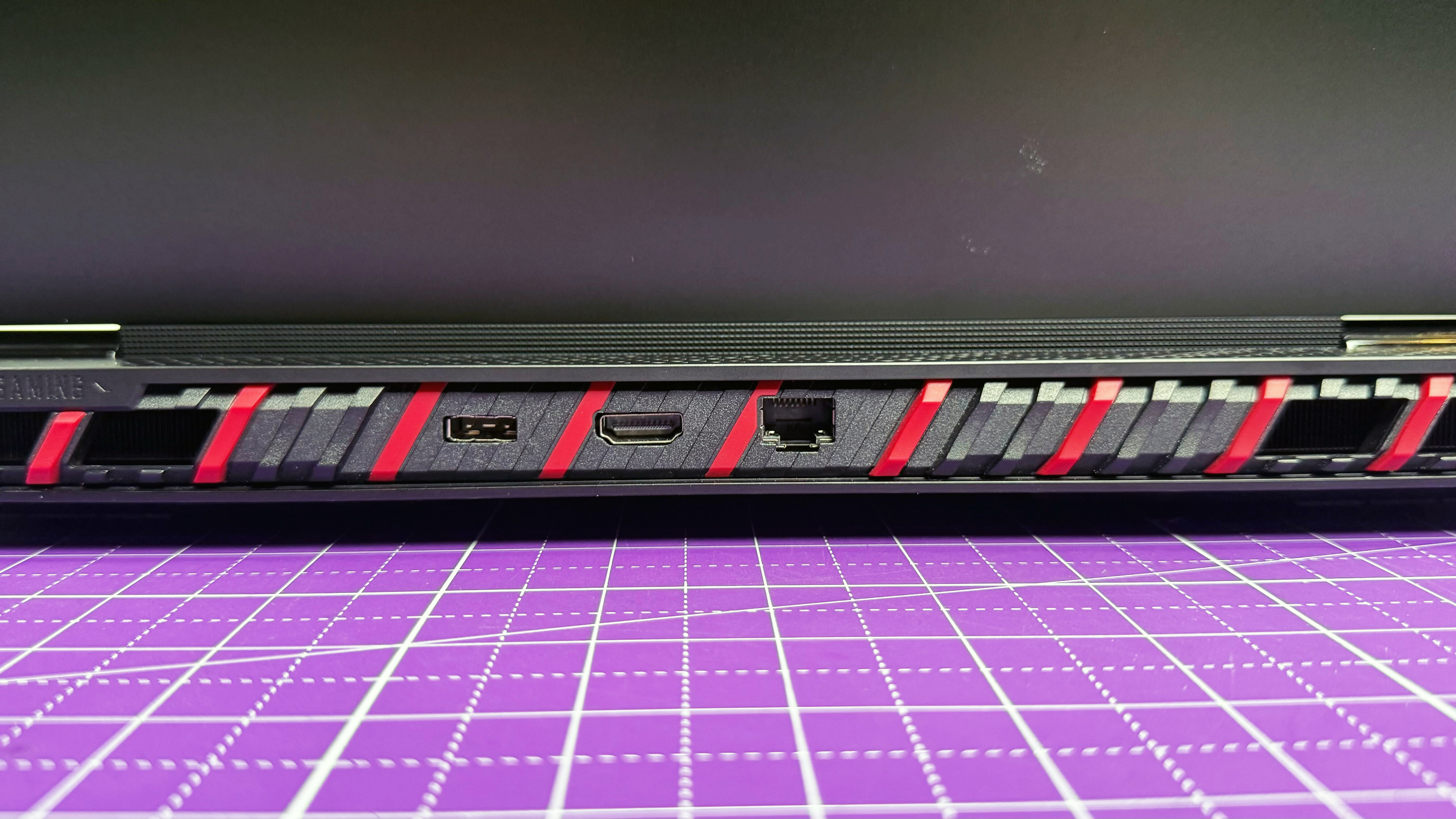 Close up of the rear ports on the MSI Raider 18 HX AI gaming laptop, on a purple mat.