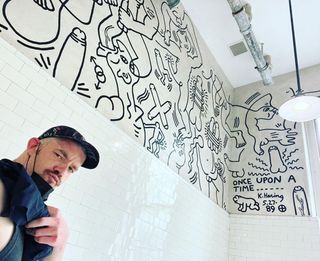 Russell Tovey pictured with a wall piece by Keith Haring