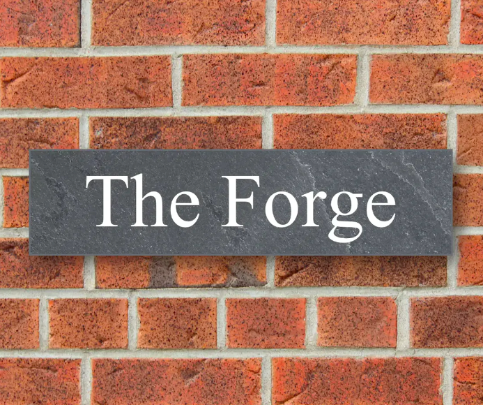 A personalised house sign on a brick wall