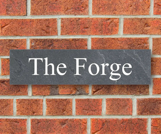 A personalised house sign on a brick wall
