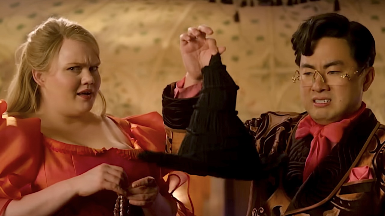 Bronwyn James and Bowen Yang disgustedly holding up Elphaba&#039;s Witch hat in Wicked