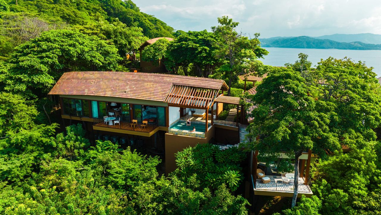 Overhead view of one of the private residences at Four Seasons Costa Rica. It is nestled in trees above the ocean.