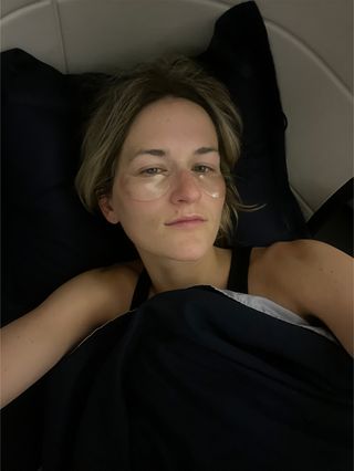 Eliza Huber lying down on an Air France Business Class trip from New York City to Paris wearing eye masks.