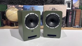 Fyne Audio Cubitt 5 speakers in olive green finish, placed on white table with records in background
