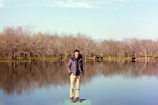 Tim Perez stands on a rock in a lake