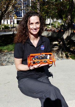 Carolyn Parcheta, a postdoctoral fellow at NASA's Jet Propulsion Laboratory in Pasadena, California, poses with the robot VolcanoBot 2, which will explore the inside of Hawaii's Kilauea volcano in March 2015.