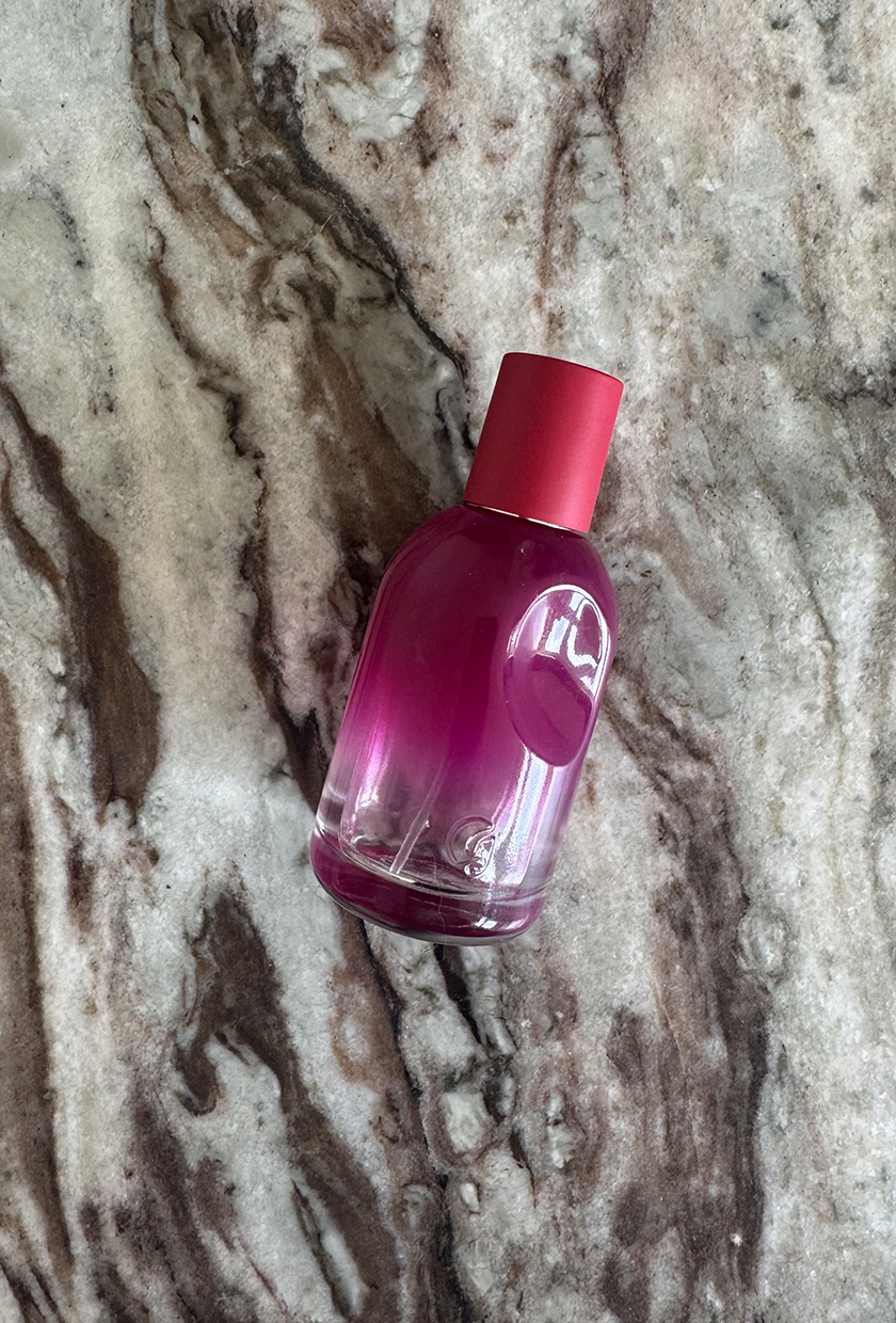 A photo of Glossier You Reve perfume on a marble table