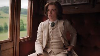 Louis Partridge as Viscount Tewkesbury riding in a train car in Enola Holmes