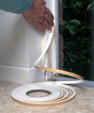 fitting self adhesive PVC foam draft excluder round a door opening to save heat