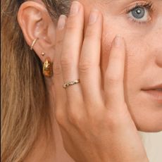 Woman wearing Astrid & Miyu earrings and rings