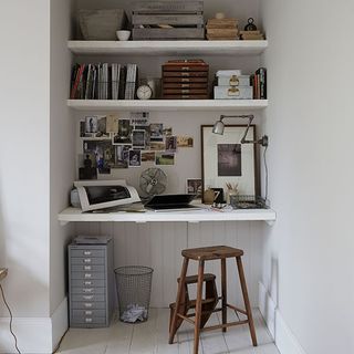 home office with shelf desk and white wall and wooden floor