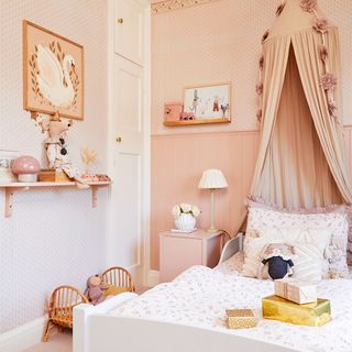 girls bedroom with pink wallpaper and canopy bed