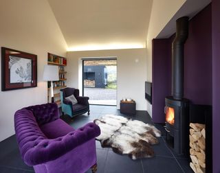 A room with Sofa,fire place and wooden shelf.