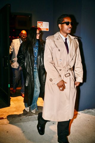 A photo of Rihanna and A$AP Rocky matching in trench coats made from leather and beige cotton gabardine respectively.