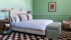 green bedroom with black and white checkerboard carpet