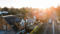Sunlight beaming down on a row of houses on a road