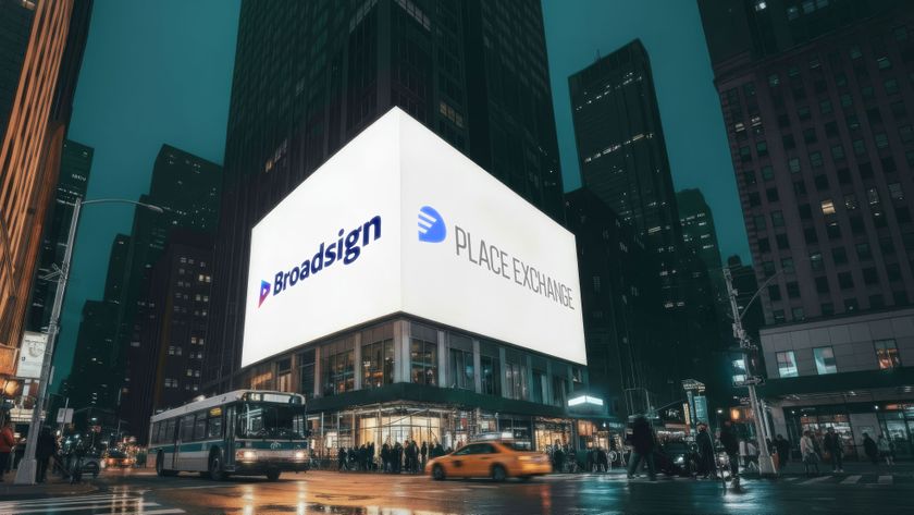 A digital billboard on the corner of a busy street, displaying the Broadsign and Place Exchange logos.