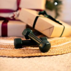 A dumbbell in front of some wrapped presents