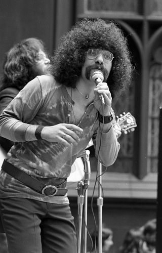 View of two unidentified musicians as they perform outside Trinity Church (at Broadway and Wall Street), New York, New York, June 19, 1970.
