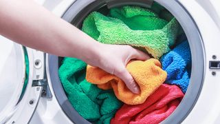 A washing machine loaded with colorful towels