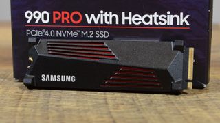 A Samsung 990 Pro on a wooden table in front of its retail packaging