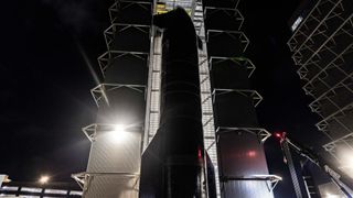 a large spaceship is seen leaving a hangar at night 