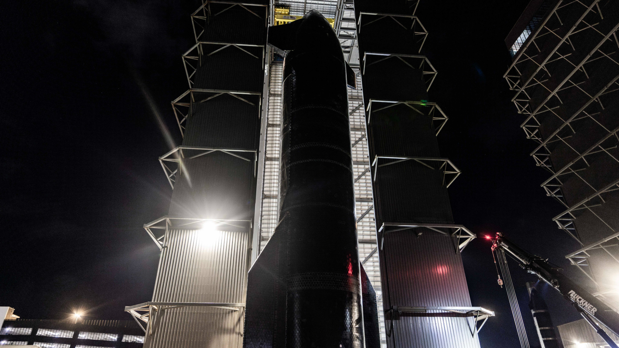 a large spaceship is seen leaving a hangar at night