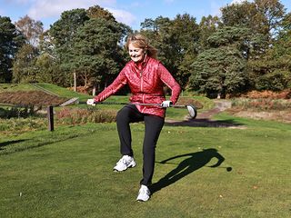 Alison Root preparing to snap her driver over her leg in frustration on the tee box